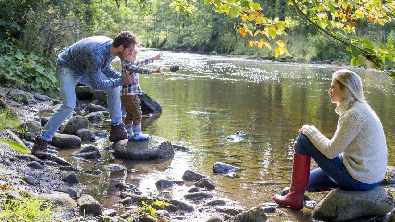 Eine Familie spielt an einem sauberen Fluss.