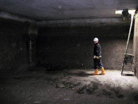 Ein Arbeiter in einem geleerten unterirdisches Regenüberlaufbecken. 