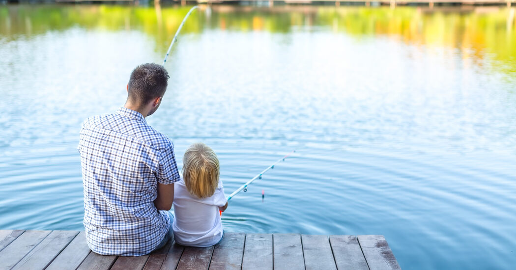 Mann und Kind angeln am See