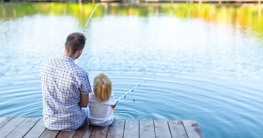 Mann und Kind angeln am See